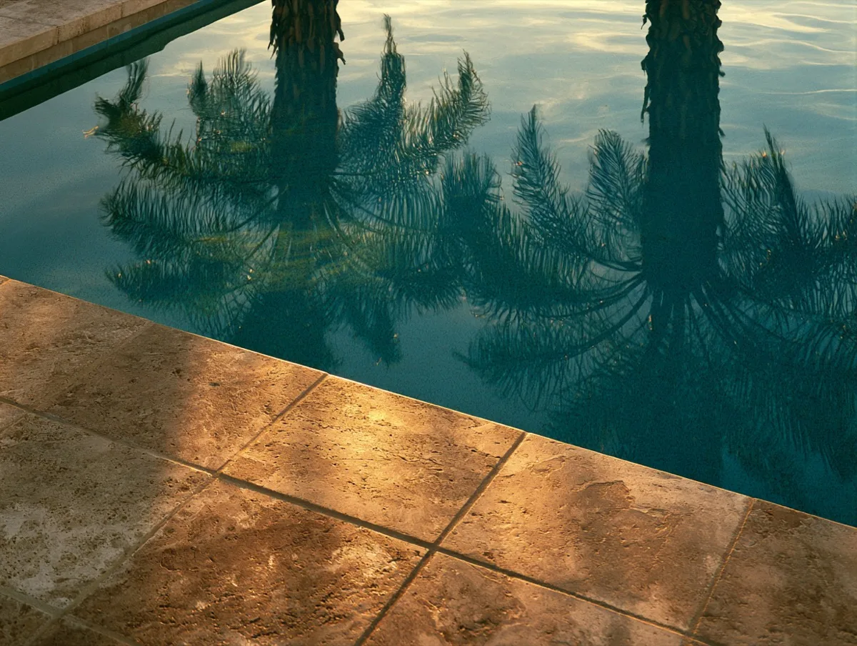 Still pool water just below a travertine edge at evening